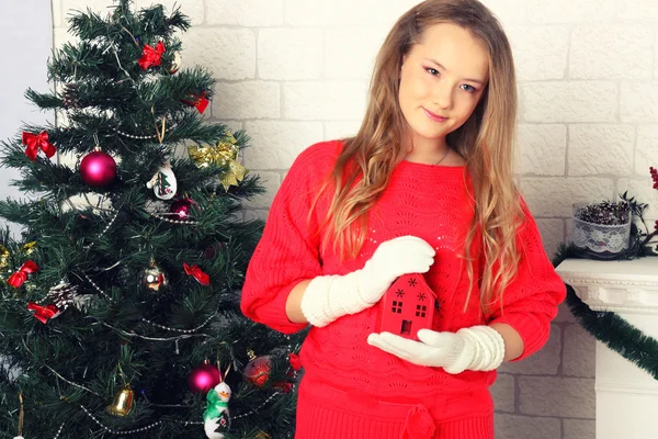 クリスマスの木の近くの赤いドレスの若い女の子 — ストック写真