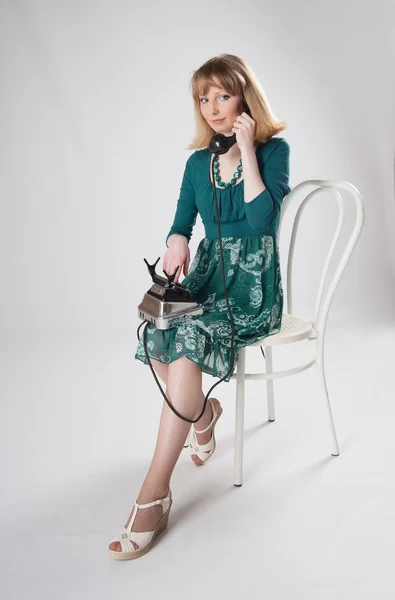 L Frau in grünem Kleid sitzt auf einem Stuhl — Stockfoto