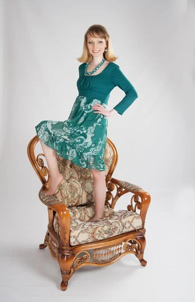 Я жінка в зеленій сукні, сидячи на стільці — стокове фото