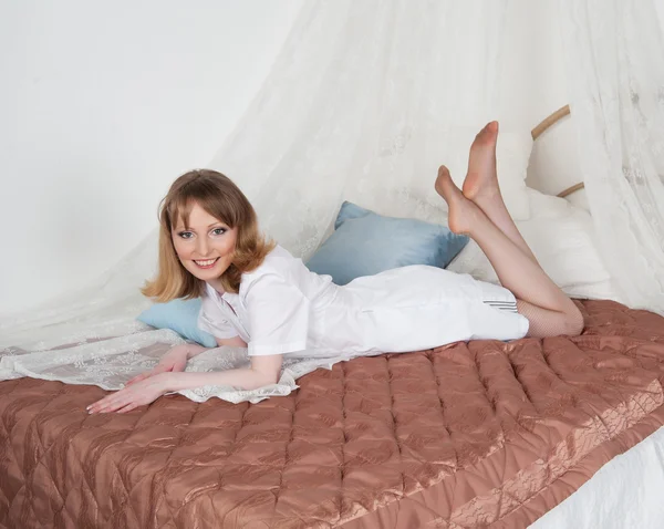 Сексуальная женщина врач на кровати — стоковое фото