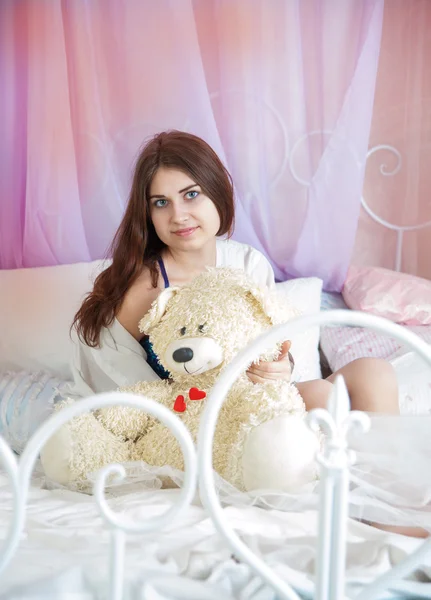 Femme au lit avec un ours en peluche — Photo