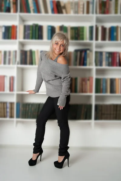 Woman standing at bookshelf — Stock Photo, Image
