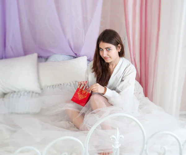 Žena v posteli otevření dar — Stock fotografie