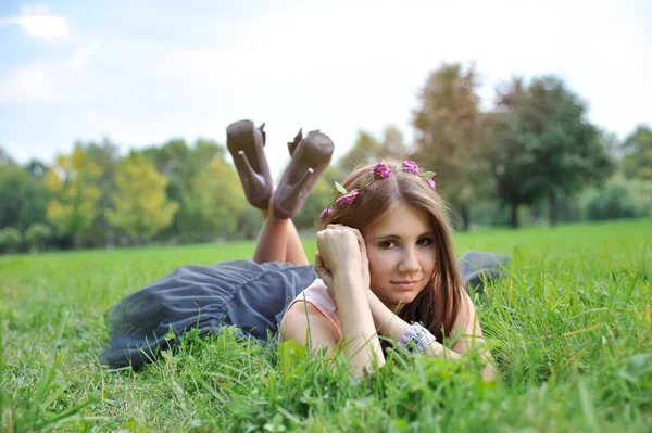 어린 소녀와 함께 잔디에 누워 화 환 — 스톡 사진