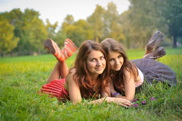 Grappig 2 vrouwen liggen op het gras — Stockfoto
