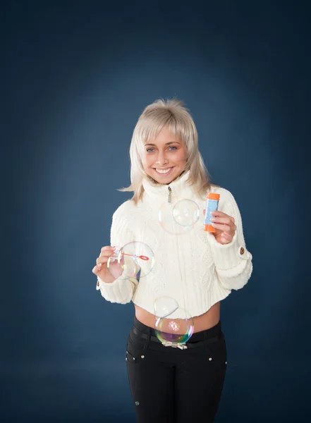 Beautiful woman blowing soap bubbles — Stock Photo, Image