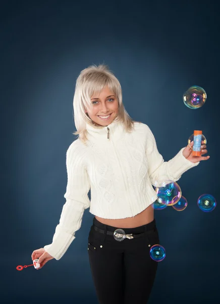 Hermosa mujer soplando burbujas de jabón — Foto de Stock