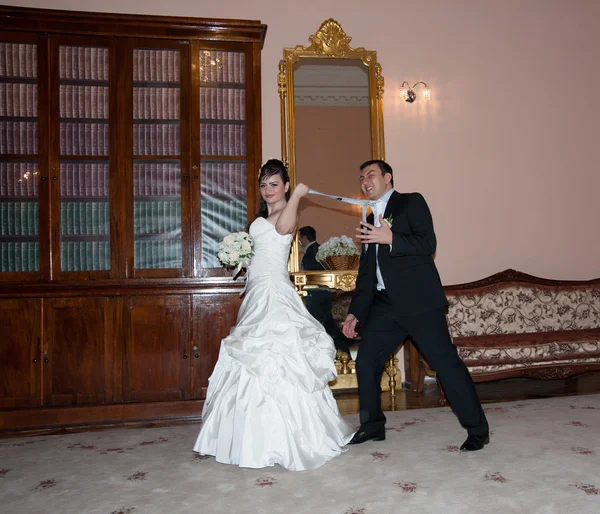 Bruden drar brudgummen för en slips — Stockfoto