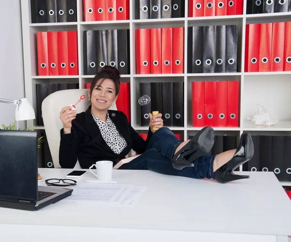 Frau pustet in Bürozeiten Seifenblasen — Stockfoto