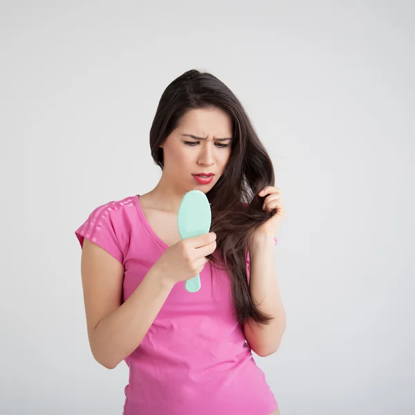 Verlies haren kammen in vrouwen hand — Stockfoto