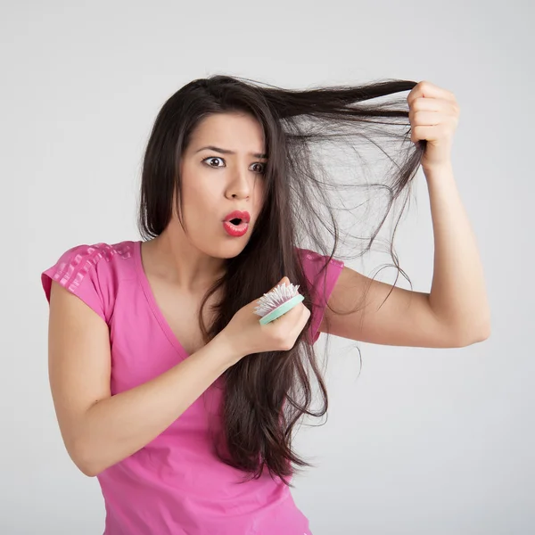 Verlies haren kammen in vrouwen hand — Stockfoto