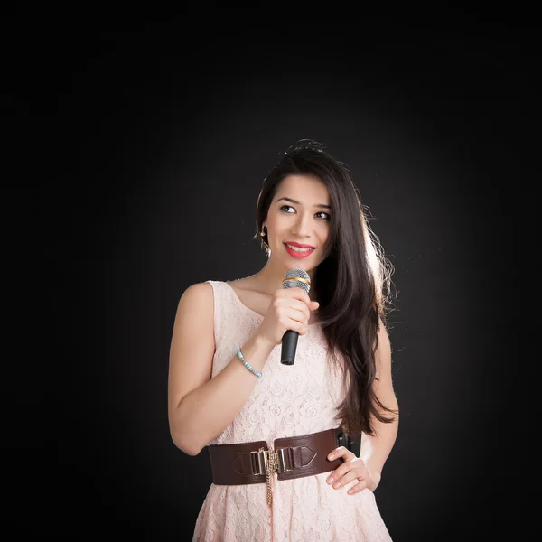 Hermosa cantante sobre un fondo negro — Foto de Stock