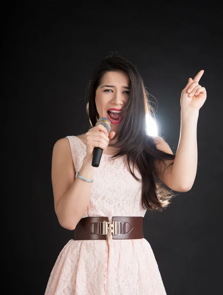 Bela cantora em um fundo preto — Fotografia de Stock