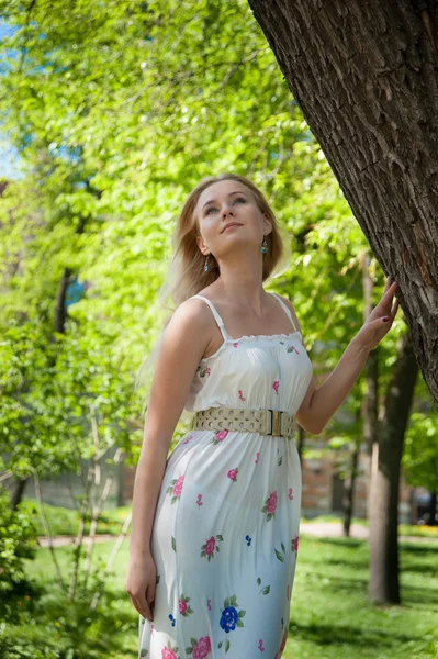 Vacker, ung kvinna som står nära trädet — Stockfoto