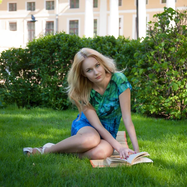 Girl is laying on the grass with a book — Stock Photo, Image