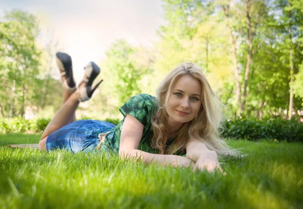 Dívka leží na trávě s knihou — Stock fotografie
