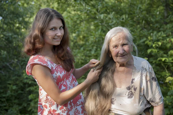 Abuela nieta peina su cabello — Foto de Stock