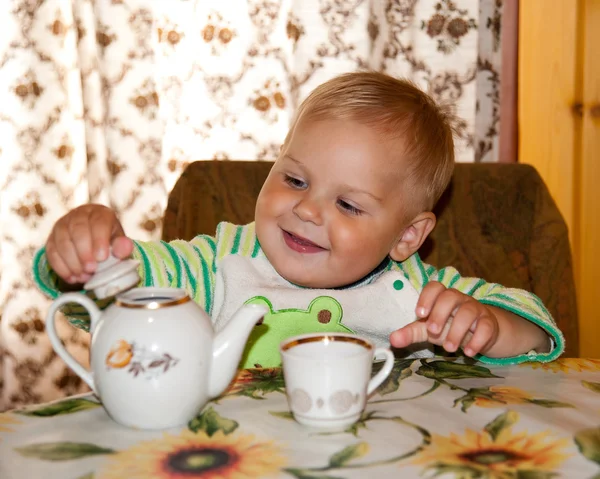 Year-old boy pours tea into a cup — Stock Photo, Image