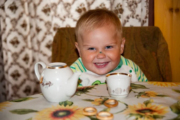 Little boy is drinking at a table — Stock Photo, Image