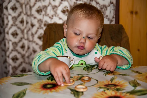 Little boy is drinking at a table — Stock Photo, Image