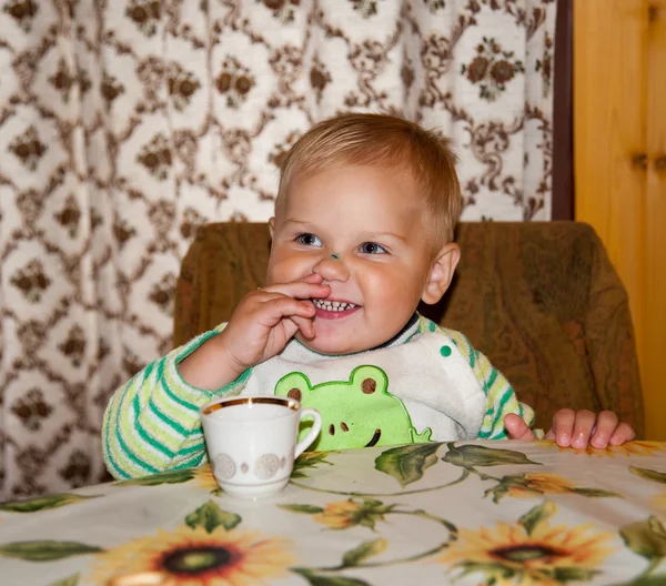 Little boy is drinking at a table — Stock Photo, Image