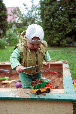 kum havuzunda oynamayı çalışma çocuk