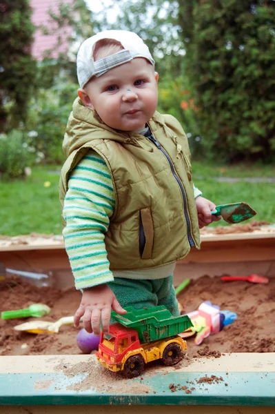 Working boy playing in a sandbox — Stock Photo, Image