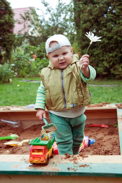 Builder boy playing in a sandbox — Stock Photo, Image