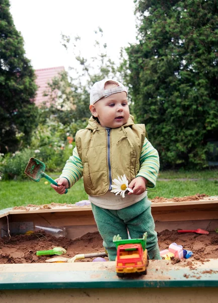 Working boy playing in a sandbox — Stock Photo, Image