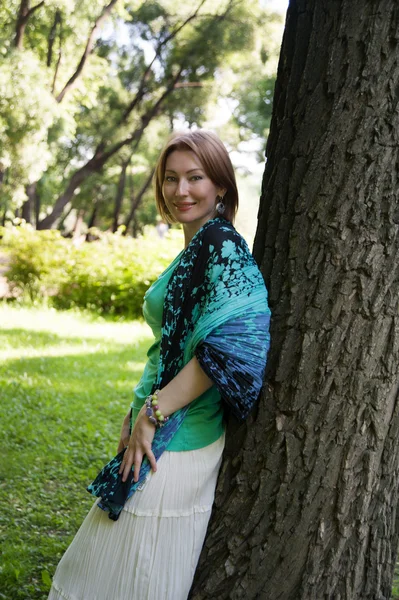 Beautiful woman at a tree in summer — Stock Photo, Image