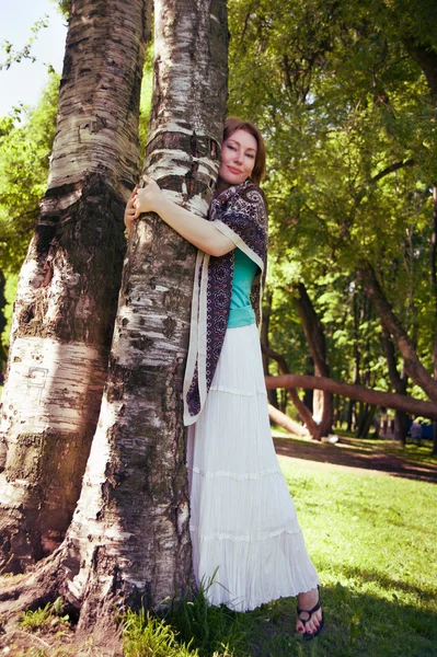 Beautiful woman at a tree in summer — Stock Photo, Image