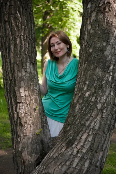 Beautiful woman at a tree in summer — Stock Photo, Image