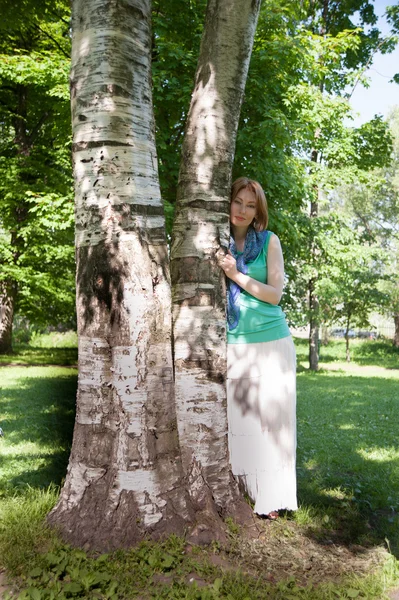 Mooie vrouw op een boom in de zomer — Stockfoto