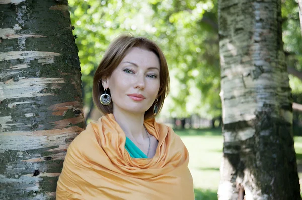 Beautiful woman at a tree in summer — Stock Photo, Image