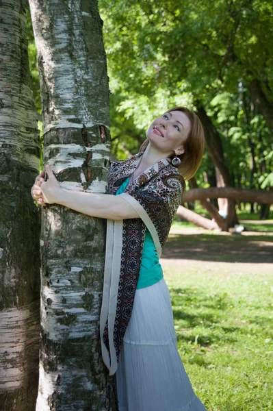 Beautiful woman at a tree in summer — Stock Photo, Image