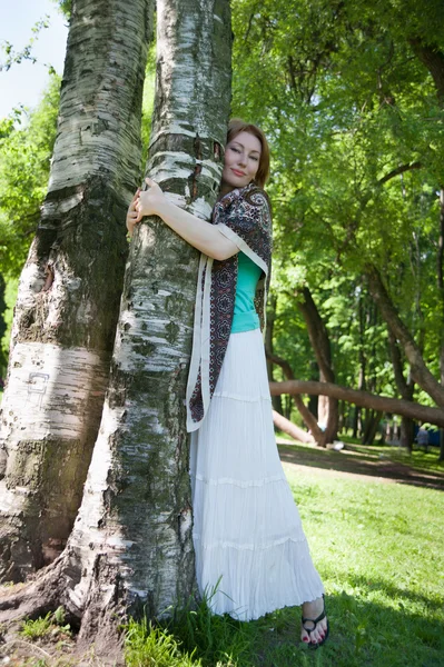 Mooie vrouw op een boom in de zomer — Stockfoto