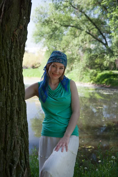 Beautiful woman at a tree in summer — Stock Photo, Image