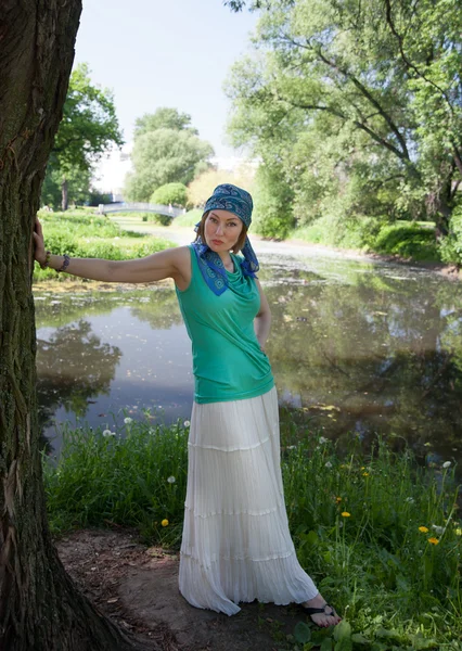 Mooie vrouw op een boom in de zomer — Stockfoto