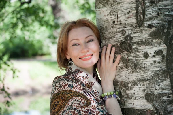 Beautiful woman at a tree in summer — Stock Photo, Image