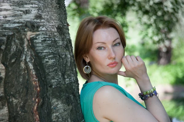 Bela mulher em uma árvore no verão — Fotografia de Stock