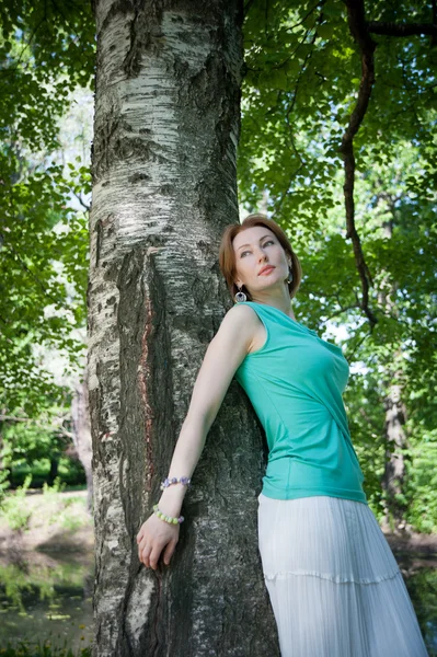 Bela mulher em uma árvore no verão — Fotografia de Stock