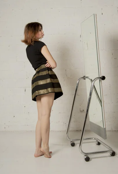 Mujer mirando en el espejo, tratando de vestir — Foto de Stock