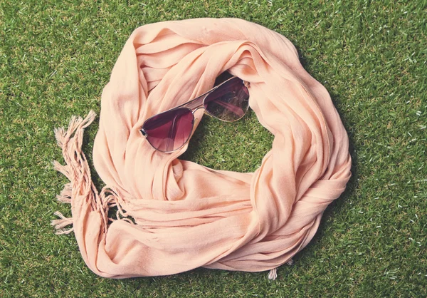 Summery pastel scarf and sunglasses on grass — Stock Photo, Image