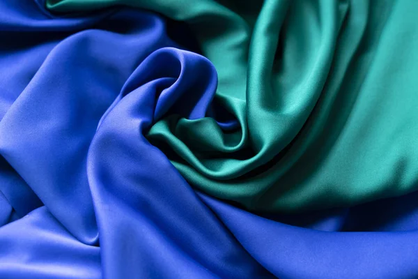 Mavi ve yeşil kumaş merkezde yaygın bir spirale dönüşür.