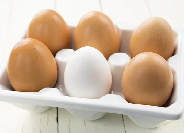 One White Egg Amongst Brown Eggs — Stock Photo, Image