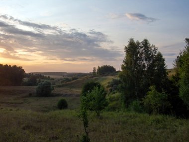 Yazın, ormanlık bir vadide, açık bir günde gün batımı