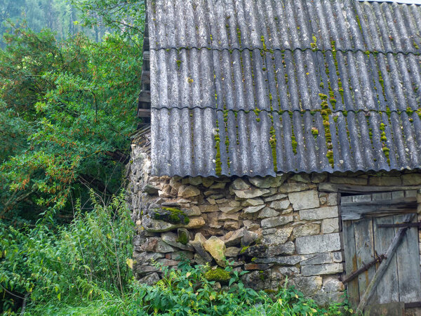 Old stone barn in the village, in summer