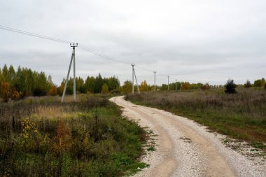Sonbaharda, bulutlu bir günde çakıl taşralı bir yol.