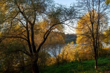 Sonbaharda, açık bir günde, büyük bir nehrin kıyısında.
