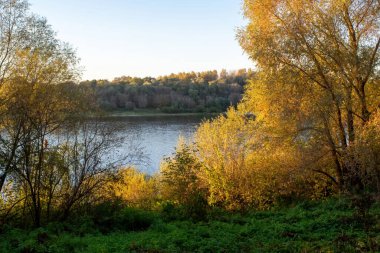 Sonbaharda, açık bir günde, büyük bir nehrin kıyısında.